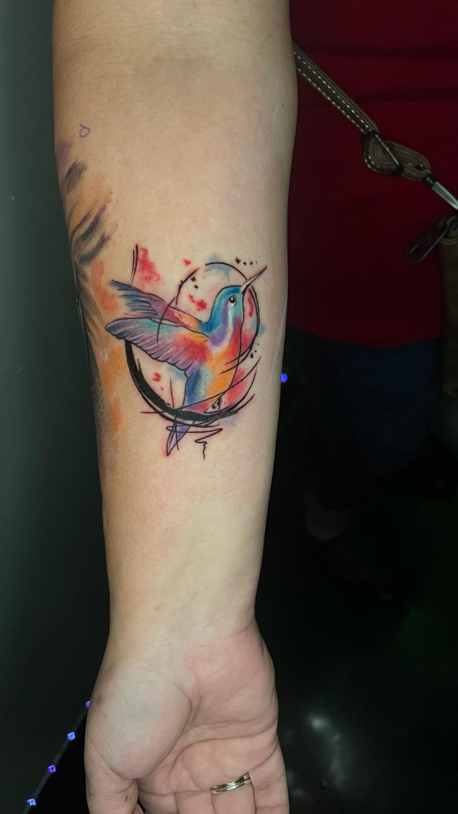 Un tatuaje pequeño de colibri a color