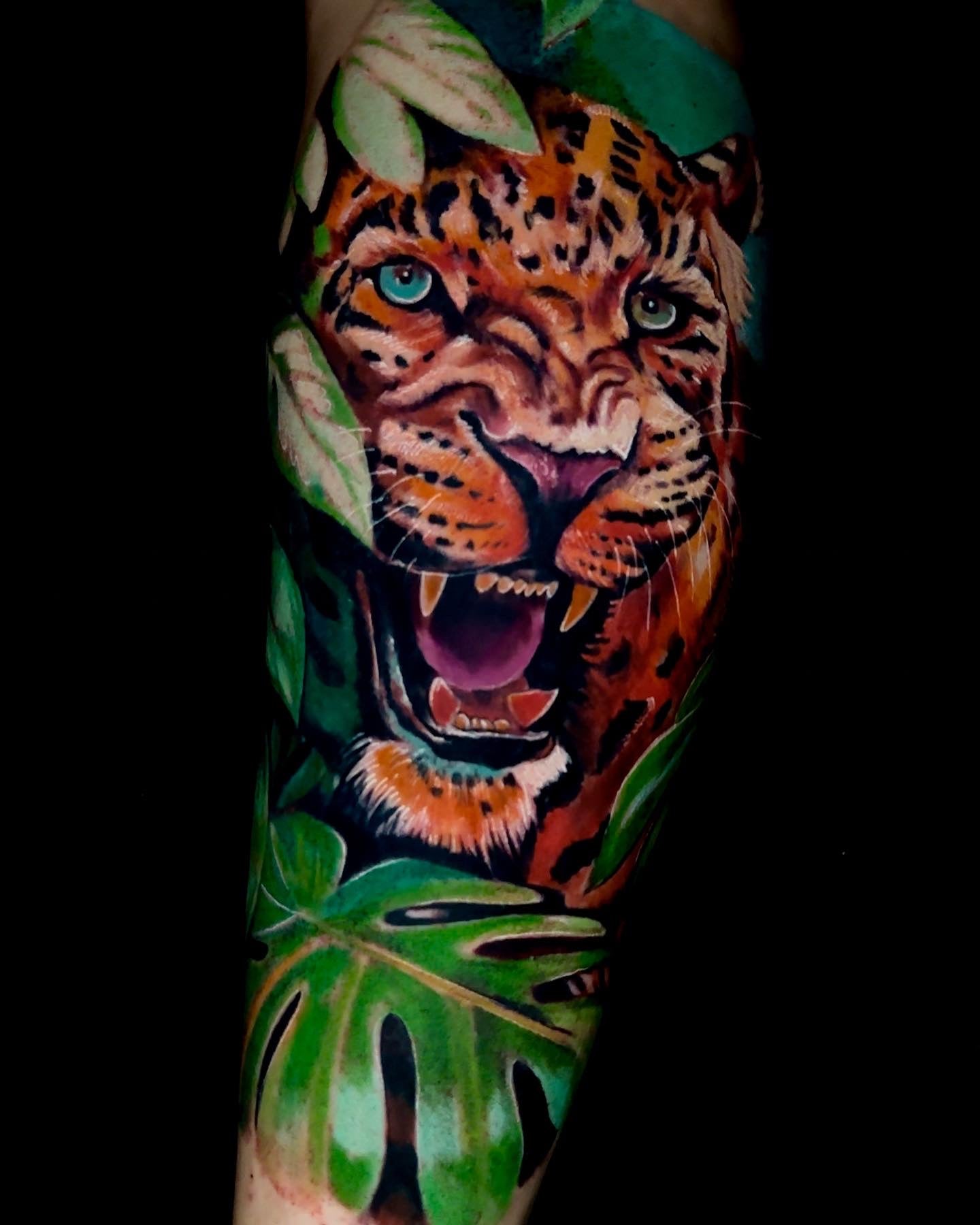 Tatuaje en el antebrazo a color de tigre y selva